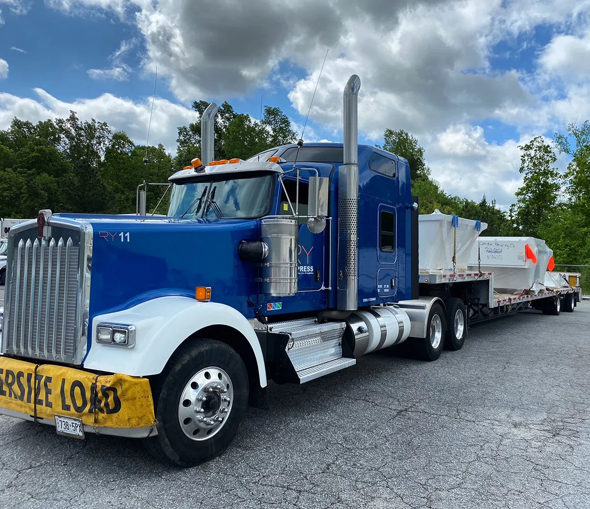 Blue RY11 Kenworth with oversize load